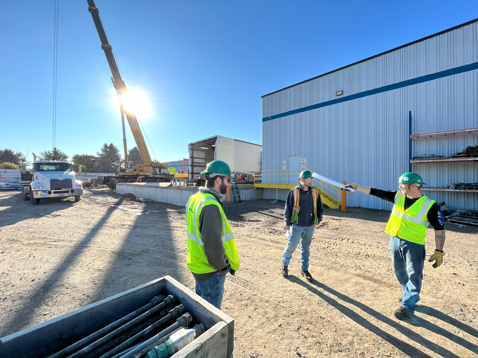 http://Lovegreen%20crew%20coordinating%20crane%20and%20rigging%20operations%20at%20an%20outdoor%20industrial%20jobsite