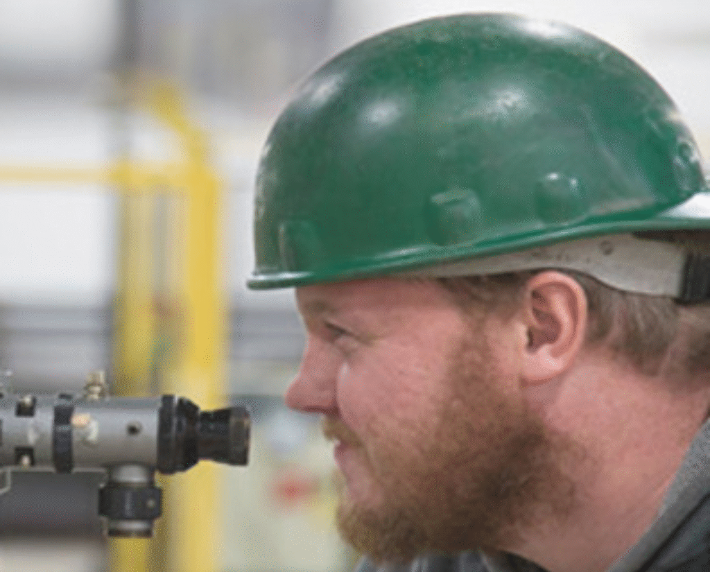 Lovegreen millwright performing precision optical alignment using traditional measurement tooling