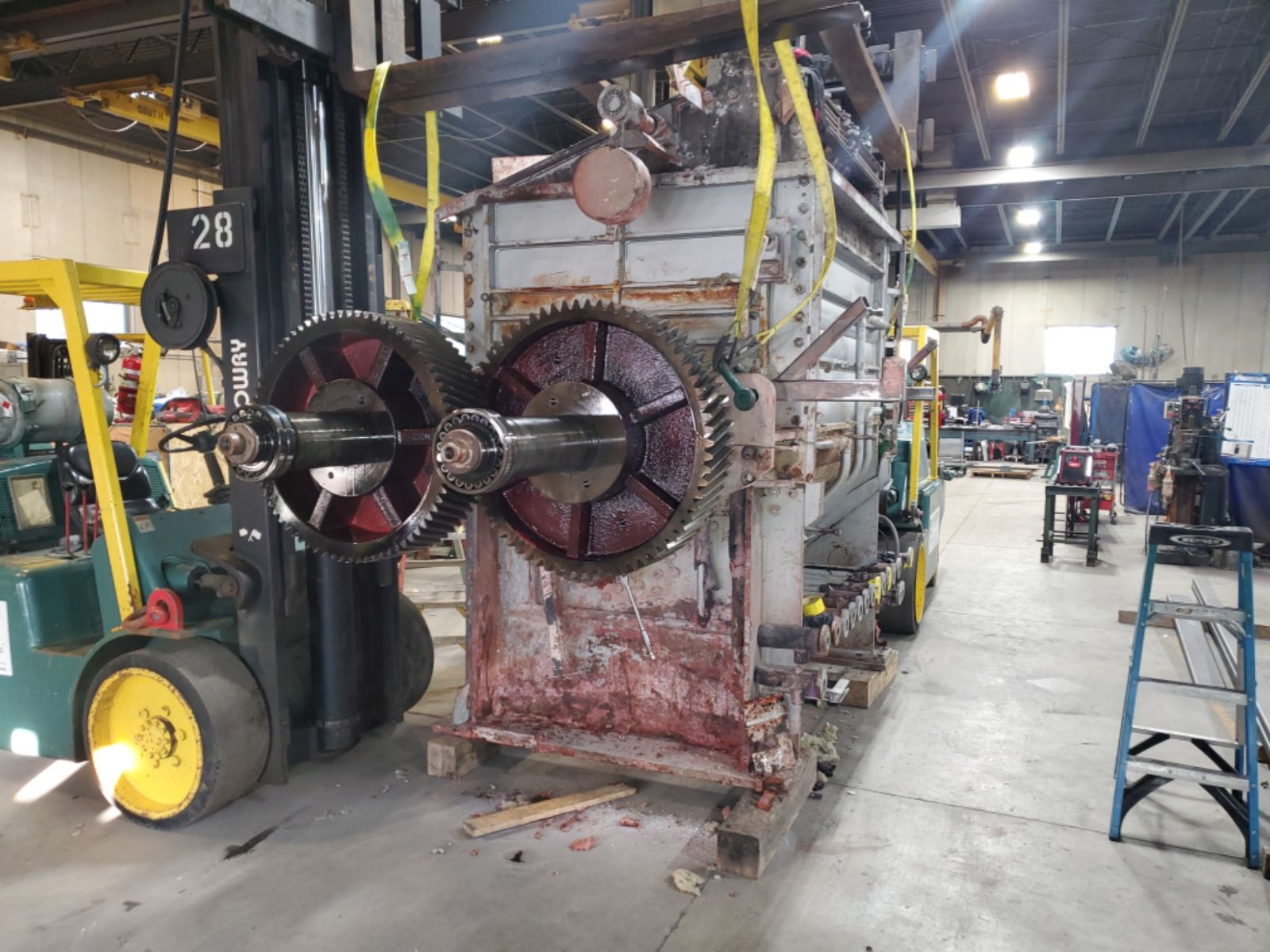 http://Disassembled%20industrial%20gearbox%20during%20repair%20work%20at%20Lovegreen’s%20facility,%20with%20exposed%20gears%20and%20shafts%20supported%20by%20forklifts